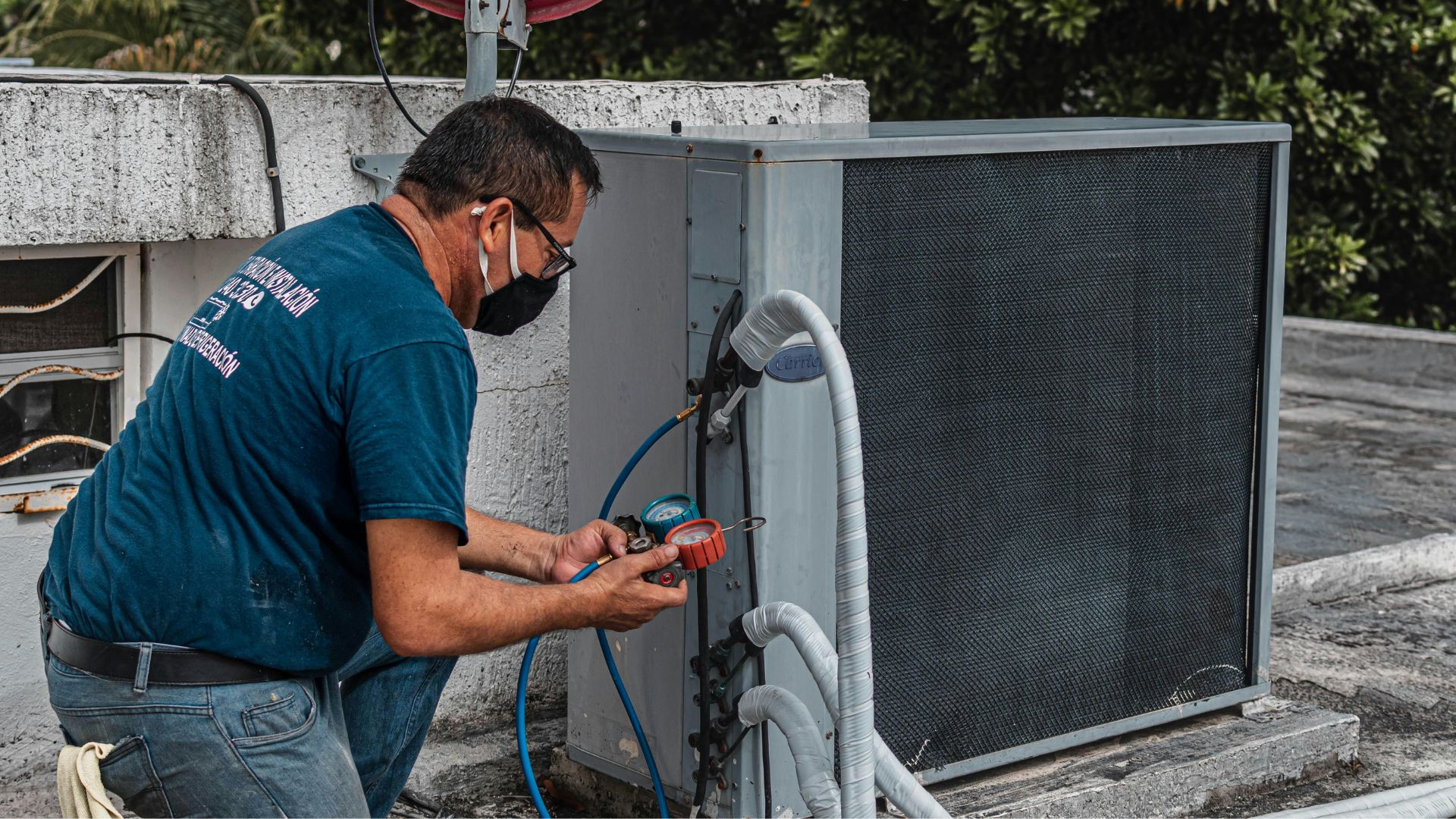 Un technicien installe une clim Un technicien installe une clim